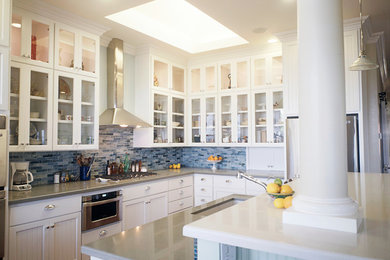 Inspiration for a large timeless l-shaped medium tone wood floor open concept kitchen remodel in San Francisco with a single-bowl sink, glass-front cabinets, white cabinets, an island, quartzite countertops, blue backsplash, porcelain backsplash and stainless steel appliances