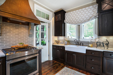 Inspiration for a mid-sized timeless l-shaped dark wood floor and brown floor enclosed kitchen remodel in Atlanta with a farmhouse sink, shaker cabinets, dark wood cabinets, granite countertops, gray backsplash, subway tile backsplash, stainless steel appliances and an island