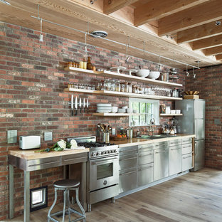 Idées déco pour une cuisine linéaire campagne avec un placard sans porte, un plan de travail en bois, une crédence en brique, un électroménager en acier inoxydable, un sol en bois clair, aucun îlot et un sol beige.