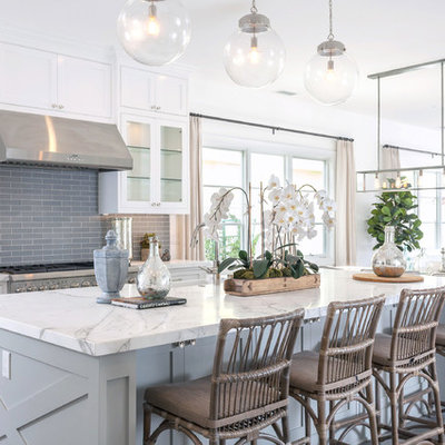 Beach style dark wood floor kitchen photo in Orange County with marble countertops, gray backsplash, an island, beaded inset cabinets, white cabinets, subway tile backsplash and stainless steel appliances