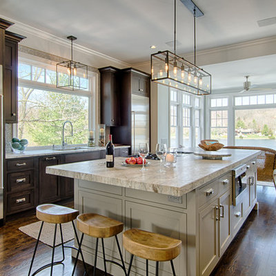 Inspiration for a large transitional u-shaped dark wood floor kitchen remodel in New York with a single-bowl sink, shaker cabinets, gray cabinets, quartzite countertops, gray backsplash, glass tile backsplash, stainless steel appliances and two islands