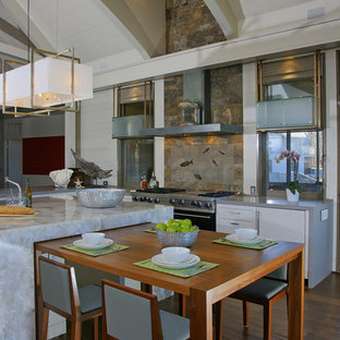 Ispirazione per una grande cucina design con paraspruzzi con piastrelle in pietra, ante bianche, ante lisce, top in onice, paraspruzzi marrone, elettrodomestici in acciaio inossidabile, parquet scuro, pavimento marrone e top grigio