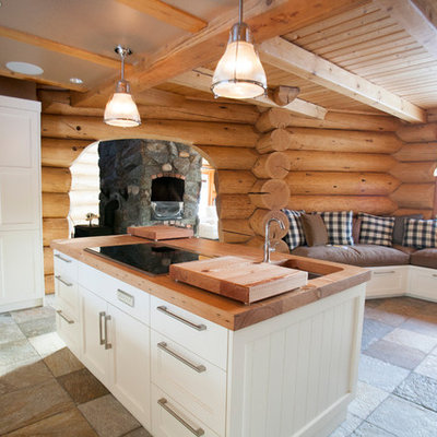 Large mountain style u-shaped slate floor eat-in kitchen photo in Vancouver with a farmhouse sink, shaker cabinets, white cabinets, wood countertops, stainless steel appliances and an island