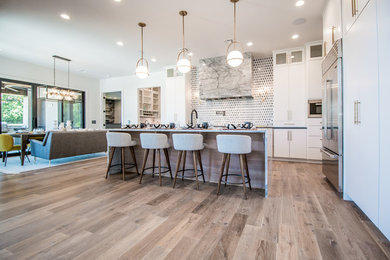 Large trendy l-shaped medium tone wood floor and brown floor eat-in kitchen photo in Other with an undermount sink, stainless steel appliances, flat-panel cabinets, white cabinets, quartzite countertops, multicolored backsplash and an island