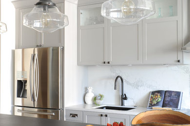 Modelo de cocina comedor contemporánea de tamaño medio con salpicadero blanco, salpicadero de losas de piedra, electrodomésticos de acero inoxidable, una isla y encimeras blancas