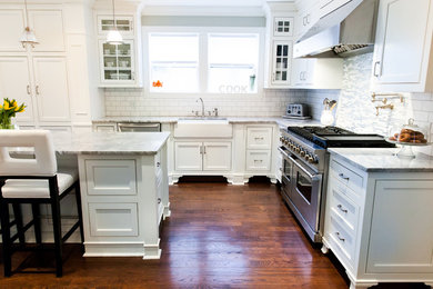 Inspiration for a huge timeless galley medium tone wood floor eat-in kitchen remodel in New York with a farmhouse sink, shaker cabinets, white cabinets, quartzite countertops, white backsplash, stainless steel appliances, an island and subway tile backsplash