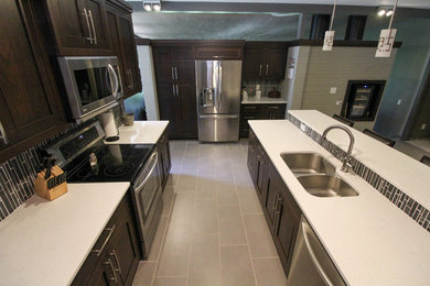Example of a trendy porcelain tile and gray floor kitchen design in Other with an undermount sink, recessed-panel cabinets, quartz countertops, gray backsplash, porcelain backsplash, stainless steel appliances and white countertops