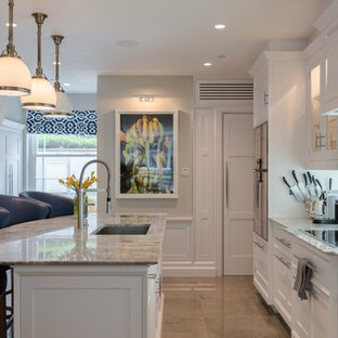 Photo of a medium sized traditional galley kitchen in London with a submerged sink, white cabinets, an island, grey floors and recessed-panel cabinets.