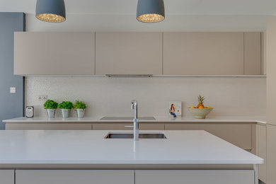 Modelo de cocina lineal minimalista grande abierta con armarios con paneles lisos, encimera de granito, una isla y encimeras blancas