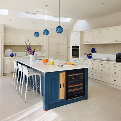 Transitional beige floor kitchen photo in London with an undermount sink, shaker cabinets, beige cabinets, beige backsplash, glass sheet backsplash, paneled appliances and an island