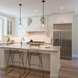 Large transitional eat-in kitchen pictures - Eat-in kitchen - large transitional l-shaped medium tone wood floor eat-in kitchen idea in San Francisco with recessed-panel cabinets, white cabinets, stainless steel appliances and an island
