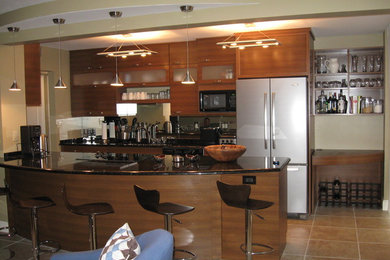 Zweizeilige, Geräumige Moderne Küche mit flächenbündigen Schrankfronten, hellbraunen Holzschränken, Granit-Arbeitsplatte, Rückwand aus Spiegelfliesen, Küchengeräten aus Edelstahl, Keramikboden, Unterbauwaschbecken und Kücheninsel in Miami