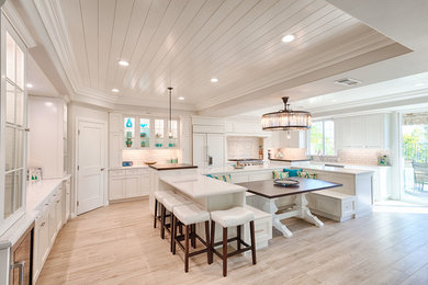 Example of a large transitional u-shaped light wood floor and beige floor eat-in kitchen design in Los Angeles with an undermount sink, recessed-panel cabinets, white cabinets, quartzite countertops, gray backsplash, marble backsplash, paneled appliances, an island and white countertops