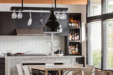 シアトルにあるミッドセンチュリースタイルのおしゃれなキッチン (淡色無垢フローリング、表し梁、フラットパネル扉のキャビネット、黒いキャビネット、白いキッチンパネル、ベージュの床、グレーのキッチンカウンター) の写真