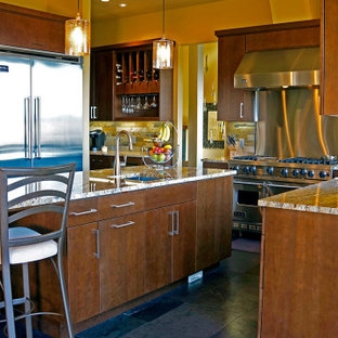 This is an example of a large arts and crafts u-shaped eat-in kitchen in Seattle with an undermount sink, flat-panel cabinets, dark wood cabinets, granite benchtops, brown splashback, slate splashback, stainless steel appliances, slate floors, with island, grey floor and brown benchtop.