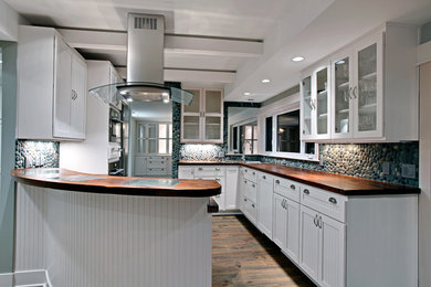 Imagen de cocina contemporánea de tamaño medio con armarios tipo vitrina, puertas de armario blancas, encimera de madera y península