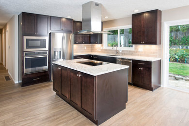 Large arts and crafts l-shaped laminate floor and brown floor open concept kitchen photo in Portland with an undermount sink, shaker cabinets, dark wood cabinets, granite countertops, beige backsplash, ceramic backsplash, stainless steel appliances, an island and beige countertops