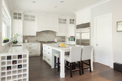Große Moderne Wohnküche in U-Form mit Doppelwaschbecken, Schrankfronten im Shaker-Stil, weißen Schränken, Küchenrückwand in Beige, Küchengeräten aus Edelstahl, braunem Holzboden und Kücheninsel in Vancouver