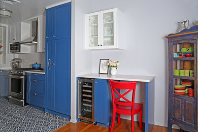 Eat-in kitchen - mid-sized traditional galley ceramic tile and multicolored floor eat-in kitchen idea in New York with an undermount sink, shaker cabinets, blue cabinets, quartz countertops, white backsplash, ceramic backsplash, stainless steel appliances and no island
