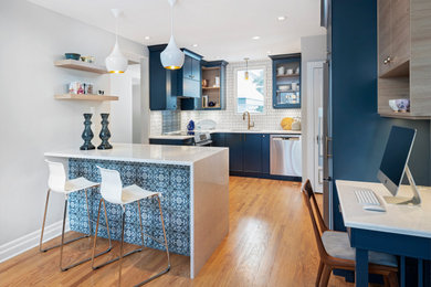 На фото: угловая кухня в современном стиле с обеденным столом, синими фасадами, столешницей из кварцевого агломерата, светлым паркетным полом и островом с