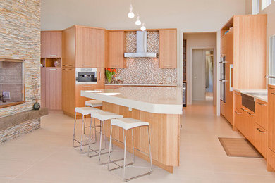 Example of a trendy l-shaped kitchen design in Vancouver with an island, flat-panel cabinets, light wood cabinets, a farmhouse sink, quartzite countertops, beige backsplash and stainless steel appliances
