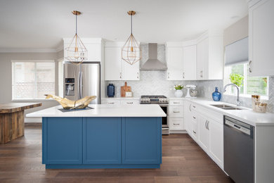 Inspiration for a mid-sized coastal l-shaped medium tone wood floor and brown floor eat-in kitchen remodel in Vancouver with an undermount sink, shaker cabinets, white cabinets, quartz countertops, white backsplash, marble backsplash, stainless steel appliances, an island and white countertops