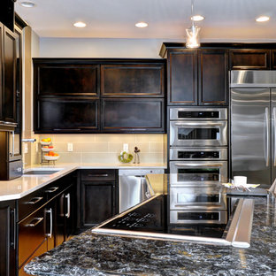 This is an example of a transitional l-shaped eat-in kitchen in Columbus with louvered cabinets, quartz benchtops, stainless steel appliances, an undermount sink, dark wood cabinets, beige splashback and ceramic splashback.