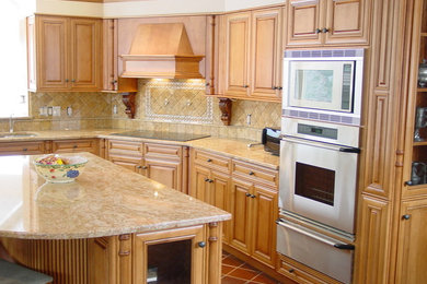 Enclosed kitchen - mid-sized traditional l-shaped terra-cotta tile enclosed kitchen idea in Boston with an undermount sink, raised-panel cabinets, light wood cabinets, granite countertops, beige backsplash, stone tile backsplash, stainless steel appliances and an island
