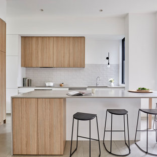 Design ideas for a contemporary l-shaped kitchen in Melbourne with an undermount sink, flat-panel cabinets, light wood cabinets, grey splashback, panelled appliances, with island, grey floor and grey benchtop.
