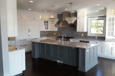 Eat-in kitchen - transitional l-shaped dark wood floor eat-in kitchen idea in New York with a farmhouse sink, recessed-panel cabinets, gray cabinets, quartzite countertops, multicolored backsplash, ceramic backsplash, paneled appliances and an island