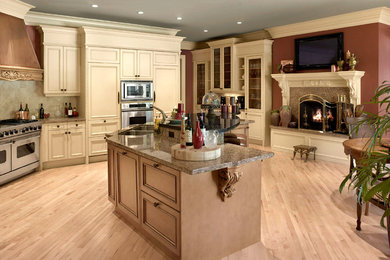 Large elegant single-wall bamboo floor eat-in kitchen photo in Cleveland with a double-bowl sink, beaded inset cabinets, white cabinets, granite countertops, beige backsplash, ceramic backsplash, stainless steel appliances and an island