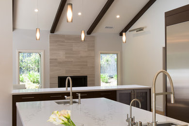 Example of a large transitional single-wall medium tone wood floor open concept kitchen design in Los Angeles with an undermount sink, flat-panel cabinets, dark wood cabinets, white backsplash, stone slab backsplash, stainless steel appliances, two islands and quartz countertops