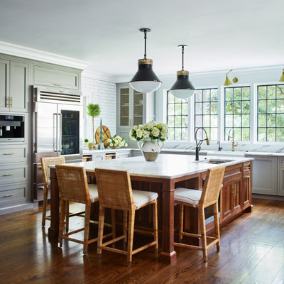 Kitchen - large cottage u-shaped medium tone wood floor and brown floor kitchen idea in New York with an undermount sink, recessed-panel cabinets, gray cabinets, marble countertops, white backsplash, ceramic backsplash, stainless steel appliances, an island and white countertops