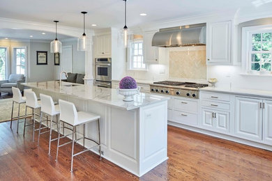 Example of a transitional kitchen design in New York with white cabinets, quartzite countertops, white backsplash, porcelain backsplash and an island
