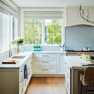 Esempio di un'ampia cucina classica con lavello sottopiano, ante in stile shaker, ante bianche, paraspruzzi blu, elettrodomestici in acciaio inossidabile, pavimento in legno massello medio, isola, pavimento marrone e top grigio