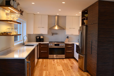 Example of a large trendy u-shaped light wood floor and brown floor kitchen pantry design in Vancouver with a double-bowl sink, flat-panel cabinets, dark wood cabinets, solid surface countertops, gray backsplash, ceramic backsplash, stainless steel appliances, no island and white countertops