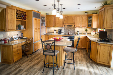 Eat-in kitchen - mid-sized traditional u-shaped medium tone wood floor eat-in kitchen idea in Other with medium tone wood cabinets, beige backsplash, black appliances, an island and raised-panel cabinets
