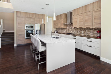 Example of a mid-sized transitional l-shaped dark wood floor open concept kitchen design in Calgary with an undermount sink, shaker cabinets, light wood cabinets, quartz countertops, multicolored backsplash, stainless steel appliances and an island