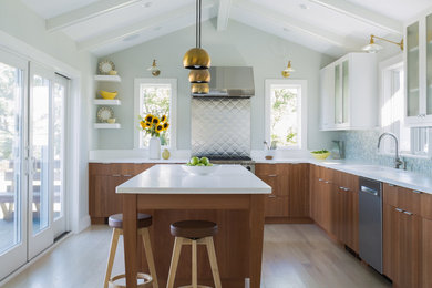 Eat-in kitchen - large modern l-shaped light wood floor and brown floor eat-in kitchen idea in Salt Lake City with white cabinets, solid surface countertops, multicolored backsplash, mosaic tile backsplash, stainless steel appliances, an island, white countertops, an undermount sink and flat-panel cabinets
