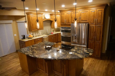 Große Urige Küche in L-Form mit Unterbauwaschbecken, profilierten Schrankfronten, Küchengeräten aus Edelstahl, braunem Holzboden und Kücheninsel in Denver