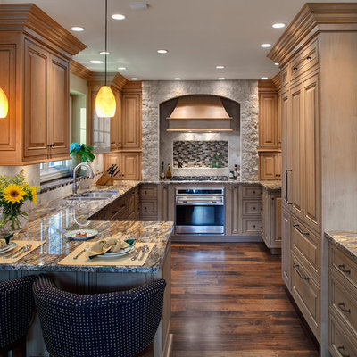 Elegant u-shaped kitchen photo in Chicago with raised-panel cabinets, light wood cabinets and paneled appliances