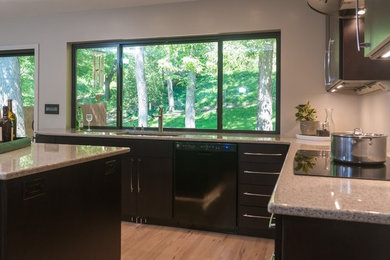Mid-sized minimalist u-shaped light wood floor eat-in kitchen photo in Kansas City with an undermount sink, flat-panel cabinets, dark wood cabinets, quartz countertops, stainless steel appliances and an island