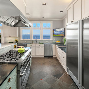 Large beach style open plan kitchen in Seattle with an undermount sink, shaker cabinets, soapstone benchtops, glass tile splashback, stainless steel appliances, slate floors, with island, green floor and green benchtop.