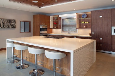 Example of a large minimalist u-shaped concrete floor and beige floor open concept kitchen design in Vancouver with flat-panel cabinets, dark wood cabinets, quartz countertops, beige backsplash, stainless steel appliances and an island