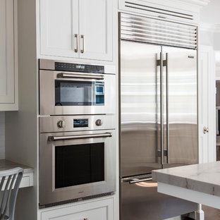 Mid-sized transitional eat-in kitchen remodeling - Mid-sized transitional l-shaped dark wood floor eat-in kitchen photo in New York with an undermount sink, shaker cabinets, white cabinets, quartzite countertops, white backsplash, ceramic backsplash, stainless steel appliances and an island