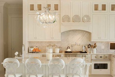 Example of a mid-sized classic l-shaped eat-in kitchen design in New York with an undermount sink, shaker cabinets, white cabinets, marble countertops, white backsplash, stone slab backsplash, white appliances and an island