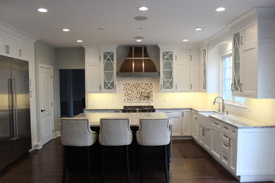 Large transitional u-shaped dark wood floor open concept kitchen photo in New York with a farmhouse sink, recessed-panel cabinets, white cabinets, quartz countertops, white backsplash, ceramic backsplash, stainless steel appliances and an island