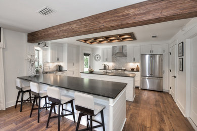 Inspiration for a mid-sized transitional galley medium tone wood floor and brown floor eat-in kitchen remodel in Jacksonville with an undermount sink, shaker cabinets, white cabinets, gray backsplash, stainless steel appliances, two islands, granite countertops and marble backsplash