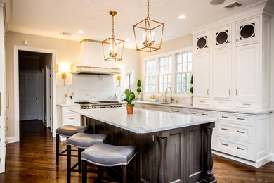 Large transitional l-shaped dark wood floor and brown floor eat-in kitchen photo with an undermount sink, recessed-panel cabinets, white cabinets, marble countertops, white backsplash, marble backsplash, paneled appliances and an island