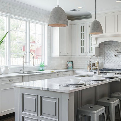 Example of a large classic l-shaped dark wood floor and brown floor kitchen design in New York with an undermount sink, white cabinets, white backsplash, subway tile backsplash, an island, gray countertops and recessed-panel cabinets